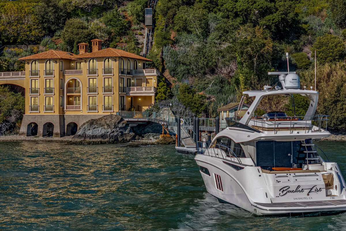 A 51-foot Sea Ray 510 Fly motor yacht, included with the listing, sits in the foreground of the bayfront estate at 125 Belvedere Ave. on Belvedere Island.